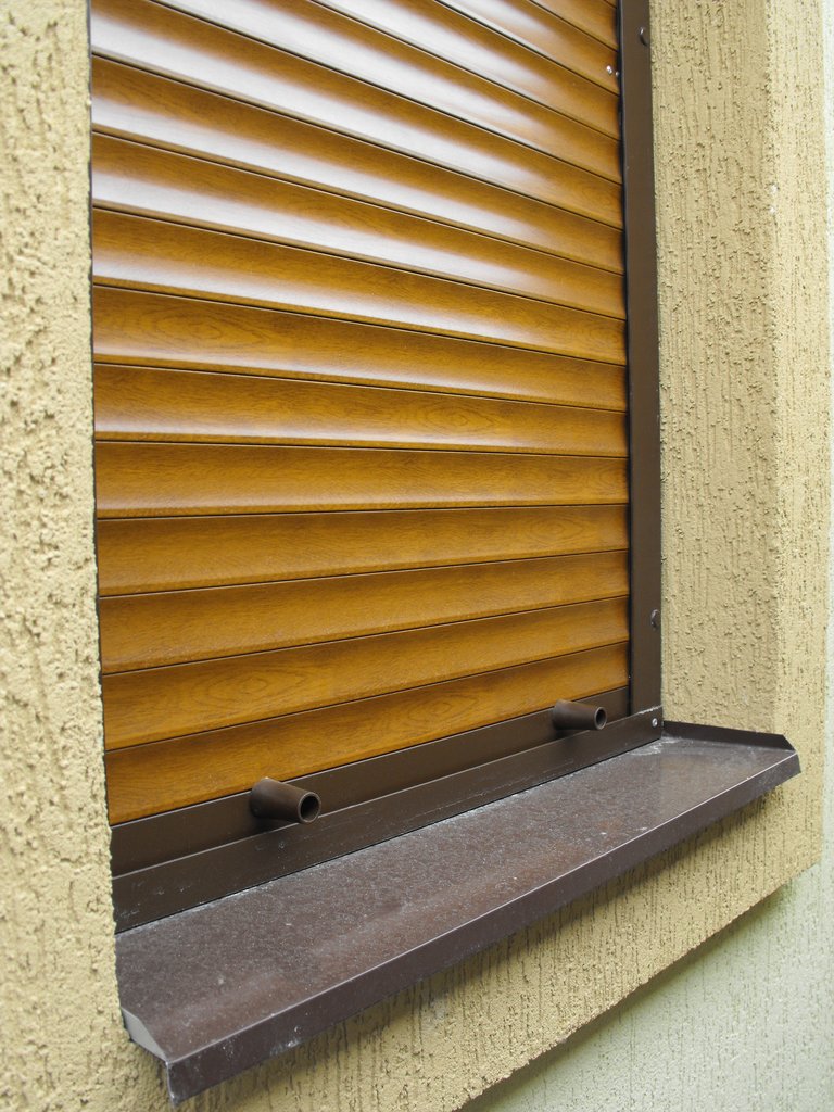 Защитная роллета окна исполненая в коричневом цвете